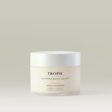 Whipped Body Velvet an intensely rich buttermelt. The product contains Madagascan vanilla extract, baobab oil, and rarabe butter. The packaging is a frosted, white jar with a white lid and a minimalistic design.
